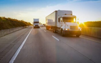 semi tractor trailer driving on the highway in the evening